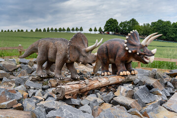 Triceratops Dinosaur Statues in Outdoor Theme Park. Realistic prehistoric animals displayed in nature. © pyansetia2008