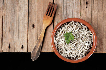 Gulas in a bowl with a wooden fork on a rustic table