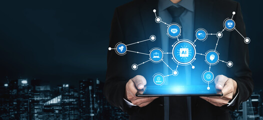 A businessman in a suit holds a tablet displaying glowing digital connection icons, symbolizing technology and innovation in a contemporary urban environment. Tessel