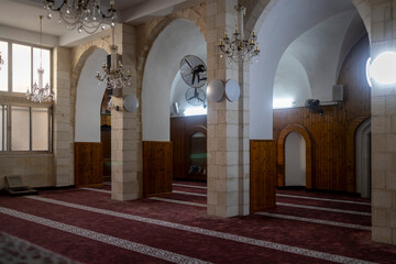 Nazareth, Israel, December 24, 2025, Interior of a mosque with stone arches, crystal chandeliers,...
