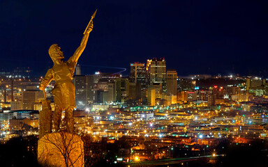 Birmingham city night view with Vulcan monument illuminated above urban landscape