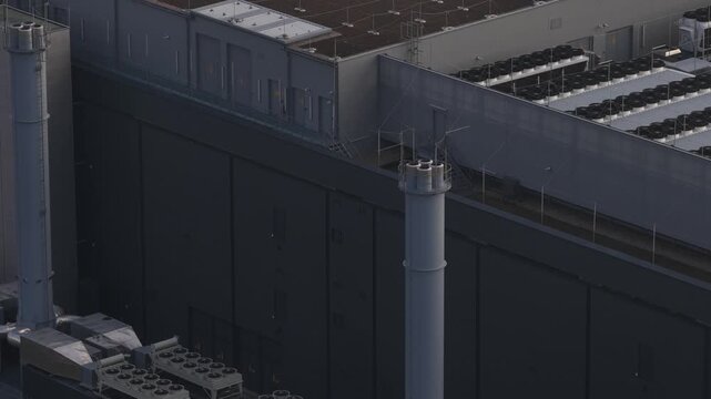 Close up aerial drone video of a modern data center facility in Berlin, showcasing high-performance computing infrastructure, storage servers, cooling systems, and emergency backup power units that