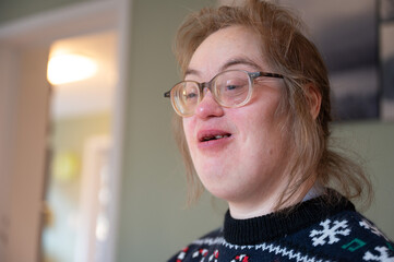 Indoor portrait of a 43-year-old woman with Down Syndrome in a warm family setting © Werner