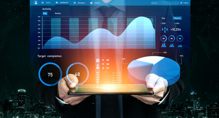 A businessman presents a tablet showcasing colorful data analytics against a nighttime city skyline, symbolizing modern innovation and technological advancement in business. Impute