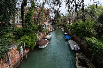 Quiet canal with moored boats in Venice, Italy