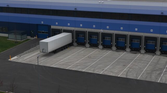 Close-up aerial drone view of a truck loading bay, showcasing logistics and transport infrastructure where freight vehicles are loaded and unloaded as part of modern supply chain operations.