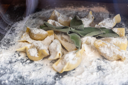 Fresh made not cooked local pasta from Bergamo cappellacci with truffles alla bergamasca, ravioli, pasta on board in local restaurant in Bergamo, Lombardy, Italy, Italian cuisine