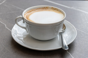 Fototapeta premium White cup of italian coffee cappuccino served in cafe in Milano, Italy
