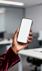 Hand holding smartphone with blank screen in office