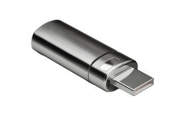 Metal USB drive placed on a flat surface in a well-lit room showing its sleek design and reflective surface