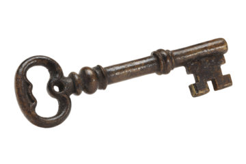 Old metal key lies on a plain surface with clear details showing its structure and design