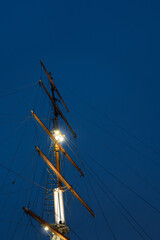 Ship mast with warm lights against deep blue Klaipeda evening sky © Indre