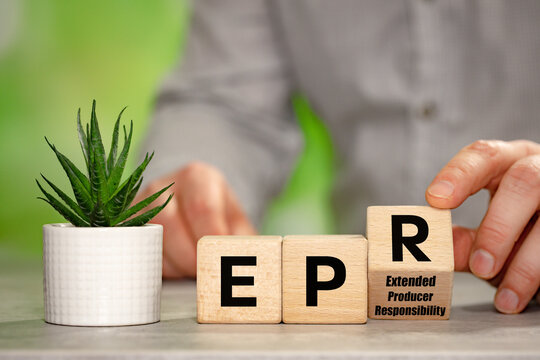 Businessman turns cubes with EPR symbol and reveals Extended Producer Responsibility. A business-environmental concept. Coverage by companies operating in the EU of recycling and environmental fees