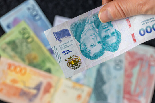 A banknote of ten thousand Argentine pesos against smaller currency. A financial and business concept. Argentina money
