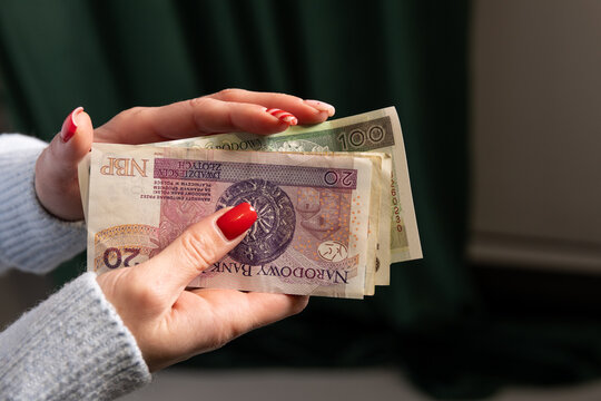 kobieta trzyma w rękach plik banknot&oacute;w. Płać got&oacute;wką
