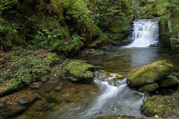 Fototapeta premium Long exposure of the big waterfall on the Hoar Oak Water river at Watersmeet in Exmoor National Park