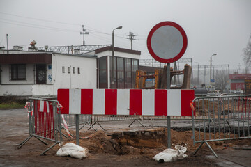 Zamknięta ulica z barierami i znakiem zakazu wjazdu podczas robót drogowych. Przebudowa infrastruktury miejskiej i tymczasowa organizacja ruchu w pochmurny dzień © Maciej Bonk