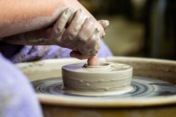 A Woman Uses a Pottery Throwing Wheel to Make a Clay Bowl