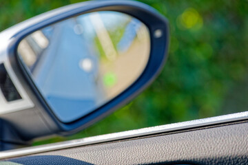 Right side car mirror with open window and bright sun