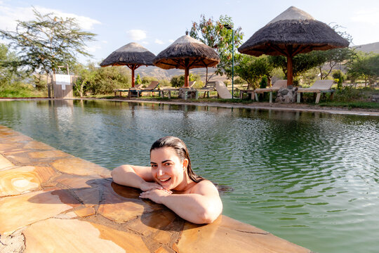 Woman relaxing in pool near Ol Doinyo Lengai volcano
