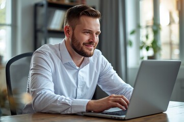 Man smiling while using laptop at desk