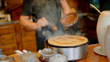 Artisan vendor expertly flipping and managing crepes on busy street corner
