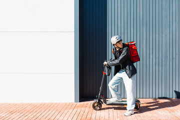 Young delivery rider on electric scooter at work