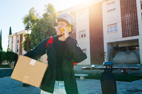 Young delivery boy on electric scooter in urban setting