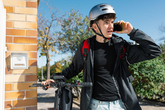 Young delivery boy on an electric scooter outdoors