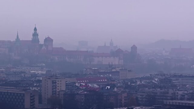 Misty aerial view of Krak&oacute;w&rsquo;s cityscape with Wawel Castle emerging through dense fog. Krak&oacute;w, Poland