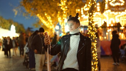 Relaxed woman explores vibrant illuminated fairground streets