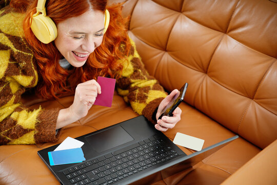 Happy woman shopping online with laptop and smartphone