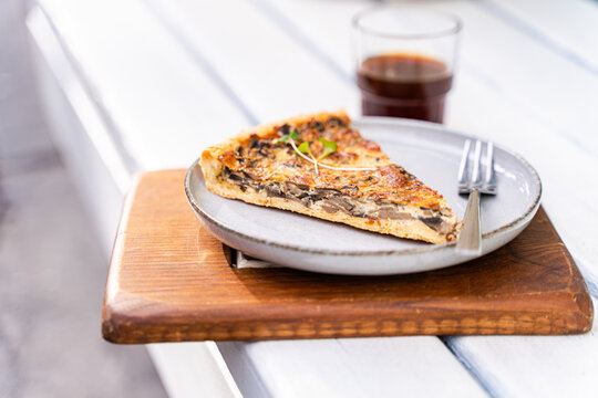Mushroom tart slice on rustic wooden board