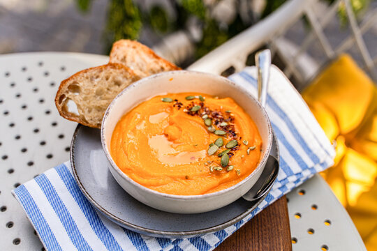 Creamy pumpkin soup with seeds and bread slice