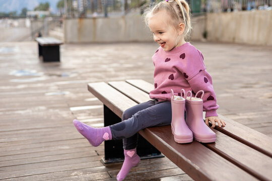 Toddler girl with rubber boots on rainy day