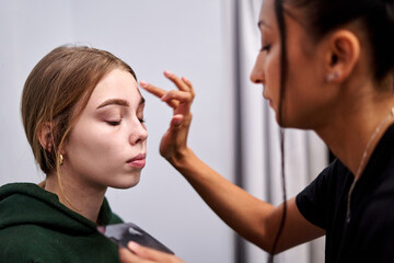 Makeup artist enhancing features for a photoshoot