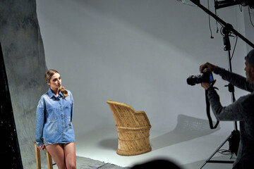 Model poses in casual denim outfit during studio photoshoot