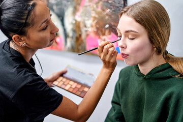 Makeup artist applies vibrant eyeshadow in studio photoshoot