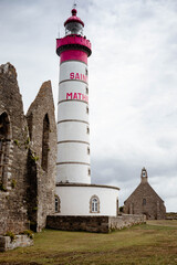 The lighthouse, chapel and abbey ruins at St Matthew point, a headland located in the commune of Plougonvelin in Finistere, Brittany, France. Side view, vertical shot.