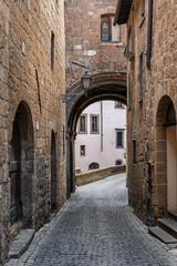 Fototapeta premium Italy - Orvieto - Medieval arch over cobbled lane - Quiet stone passage winding through the histori