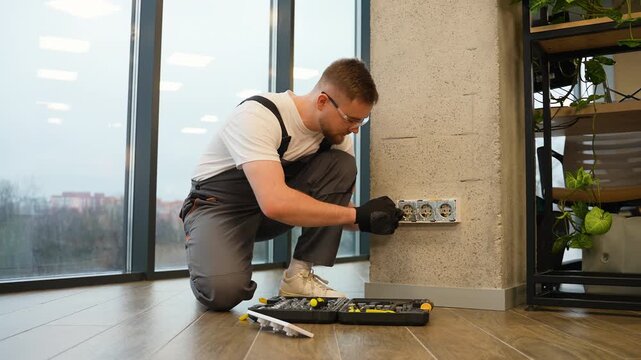 Professional electrician installing new electrical wall sockets