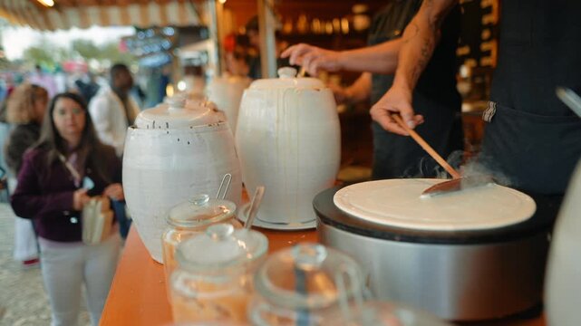 Vendors and onlookers gather to watch pancake preparation process