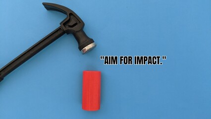 Hammer above red cylinder on blue background conveys precision, strength, and purposeful impact with motivational message.