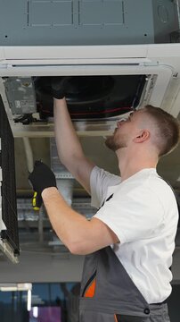 Technician repairing and installing ceiling air conditioner
