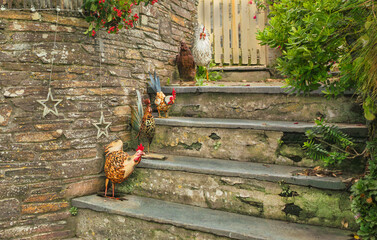 Ornate metal chickens on the steps leading into a seaside house