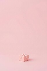 Minimalist pink gift box with ribbon on pastel background
