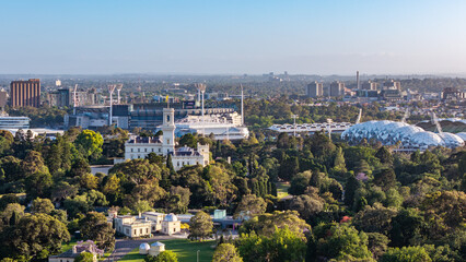 Fototapeta premium Panoramic Daytime View of Melbourne, Australia, Featuring Historic Government House, Lush Royal Botanic Gardens, and Major Sports Stadiums