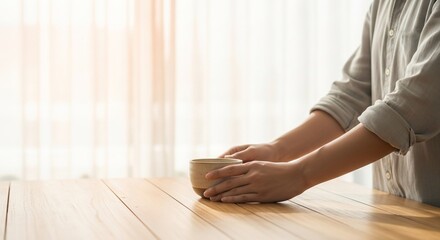 Person Holding Coffee Cup on Wooden Table.