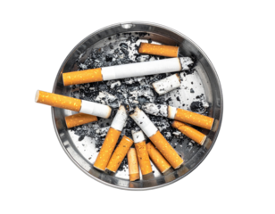 Overhead shot of a circular ashtray filled with discarded and partially burnt cigarettes