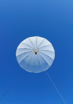 White Tethered Balloon Ascending in a Clear Blue Sky